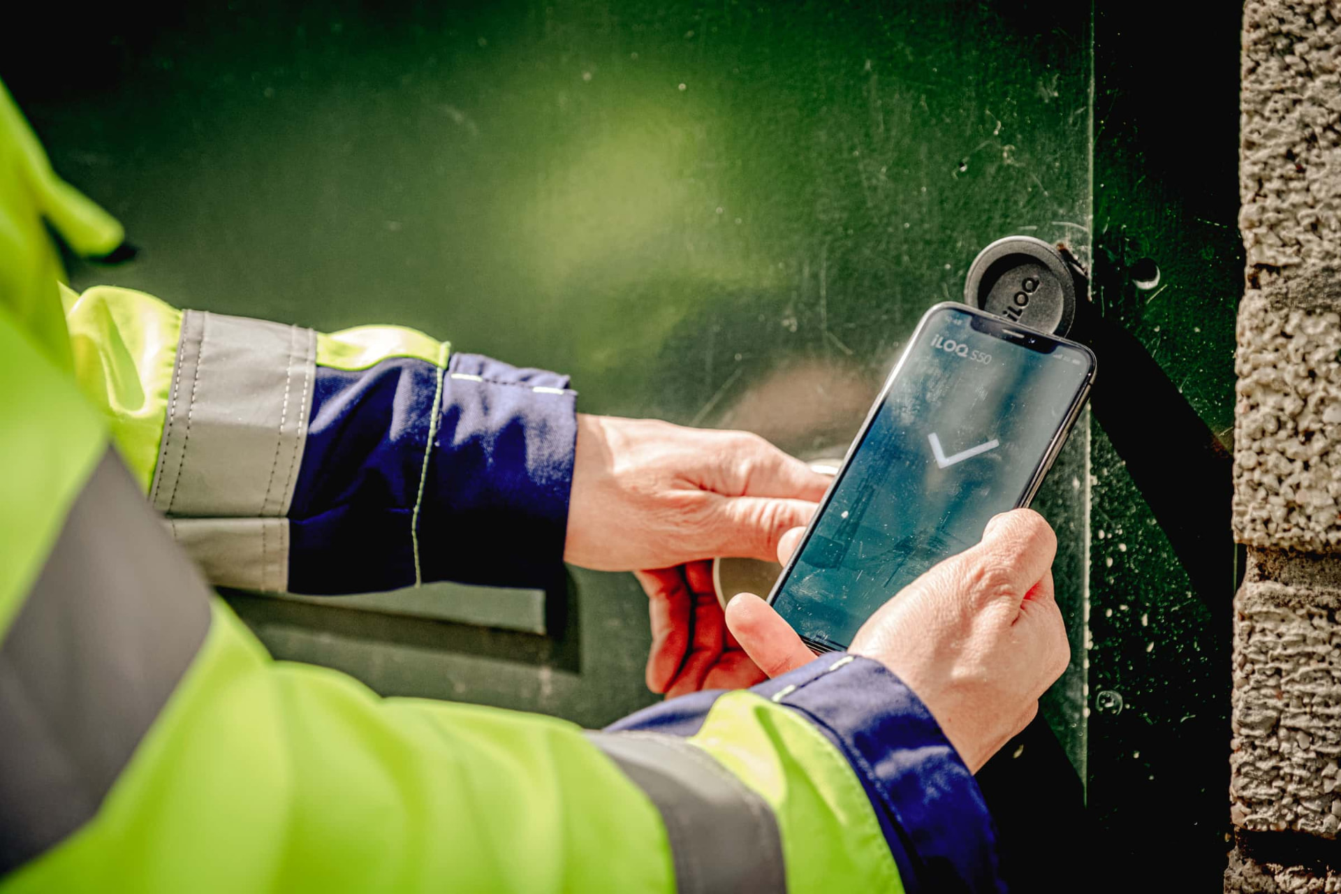 Field technician unlocking an iLOQ S50 smart cylinder with a smartphone